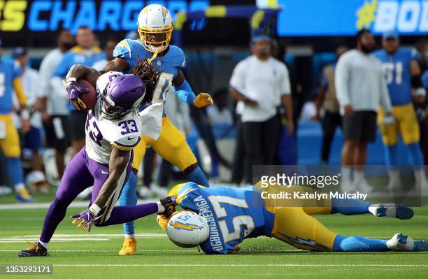Dalvin Cook of the Minnesota Vikings carries the ball as Amen Ogbongbemiga of the Los Angeles Chargers attempts a tackle during the first quarter of...