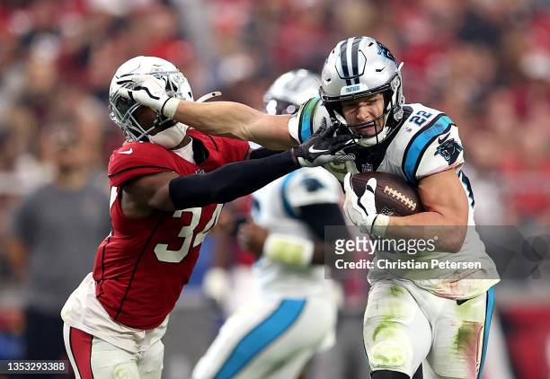 Christian McCaffrey of the Carolina Panthers stiff arms Jalen Thompson of the Arizona Cardinals in the first half at State Farm Stadium on November...