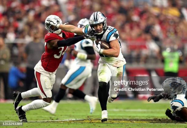 Christian McCaffrey of the Carolina Panthers stiff arms Jalen Thompson of the Arizona Cardinals in the first half at State Farm Stadium on November...