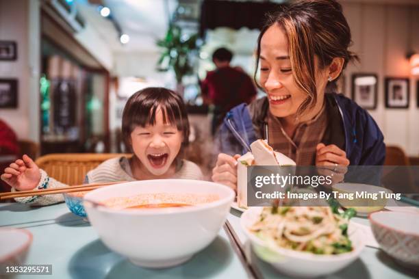 mom & daughter having meal joyfully in restaurant - thai food fotografías e imágenes de stock