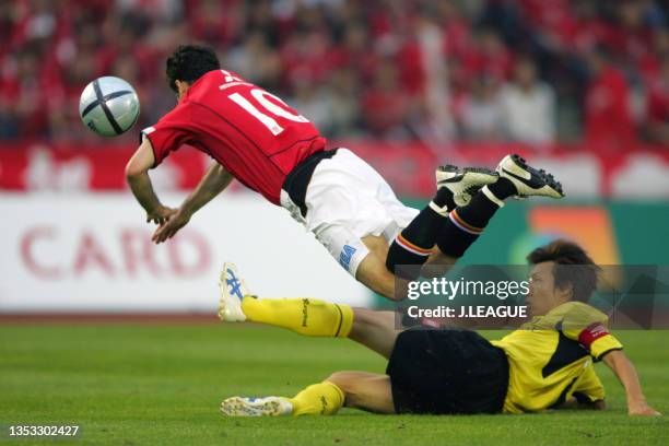 Robson Ponte of Urawa Red Diamonds is tackled by Yasuhiro Hato of Kashiwa Reysol during the J.League J1 match between Urawa Red Diamonds and Kashiwa...