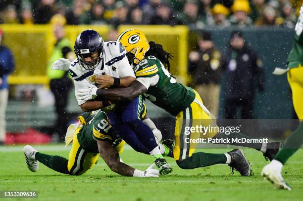 Russell Wilson of the Seattle Seahawks is tackled by De'Vondre Campbell and Preston Smith of the Green Bay Packers during the fourth quarter at...