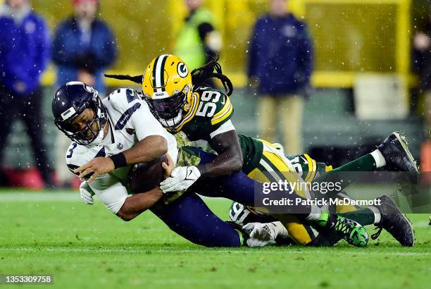 Russell Wilson of the Seattle Seahawks is tackled by De'Vondre Campbell of the Green Bay Packers during the fourth quarter at Lambeau Field on...