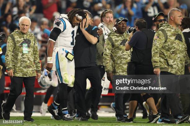 Quarterback Cam Newton of the Carolina Panthers walks to mid-field with head coach Matt Rhule after defeating the Arizona Cardinals in the NFL game...