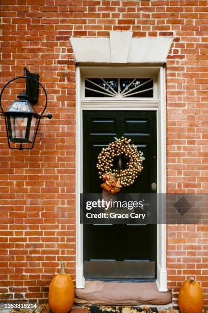 front door decorated with orange wreath - pumpkin decorating stock pictures, royalty-free photos & images