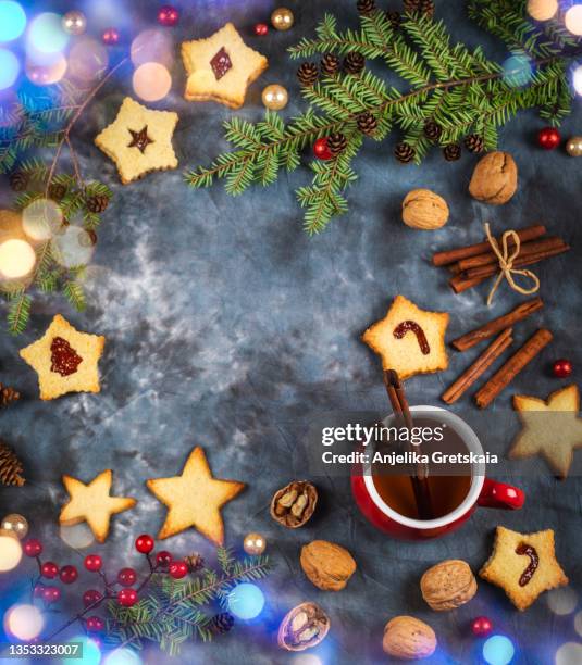 christmas background with linzer cookies, tea, nuts and holiday decor. - linzertorte stock-fotos und bilder