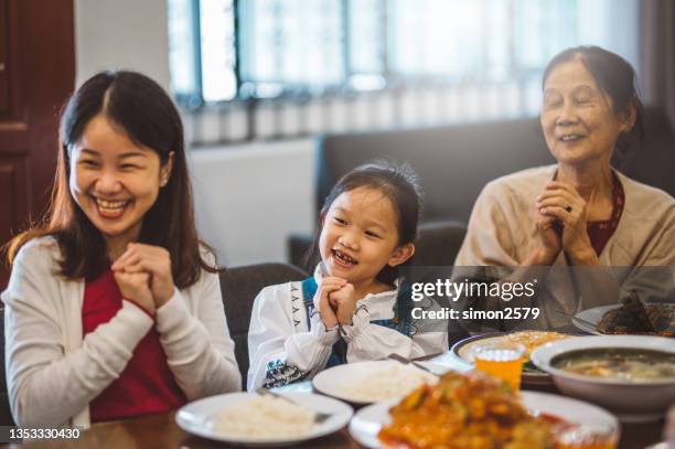 fröhliche asiatische familie mit online-gruß zum chinesischen neujahr und treffen mit verwandten per videoanruf zu hause während des wiedersehensessens - chinese new year food stock-fotos und bilder