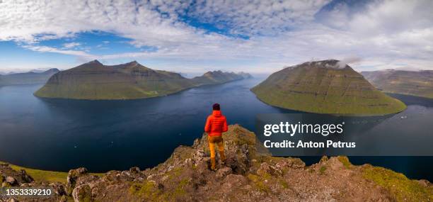 man on a cliff with view of fjord from klakkur mountain. klaksvík, faroe islands - faroe islands bildbanksfoton och bilder