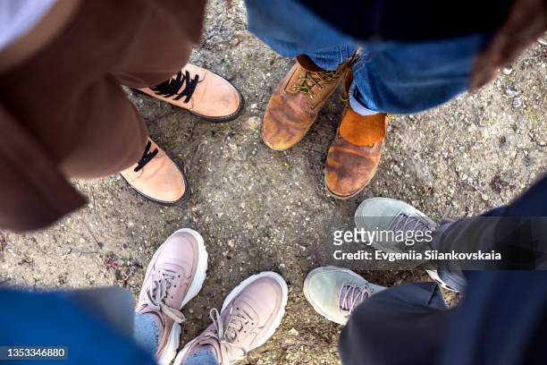 four friends wearing different shoes - sneaker and boots outdoors. - suede shoe stock pictures, royalty-free photos & images