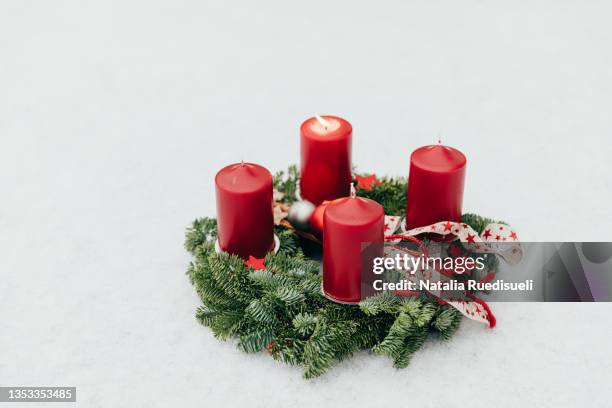 celebrating days until christmas in switzerland, lighting the first candle on advent wreath. - christmas candles stockfoto's en -beelden