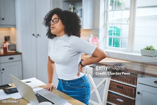 自宅でラップトップで彼女の仕事を完了した後、腰痛に苦しむ若い美しい女性のショット - 腰痛 ストックフォトと画像