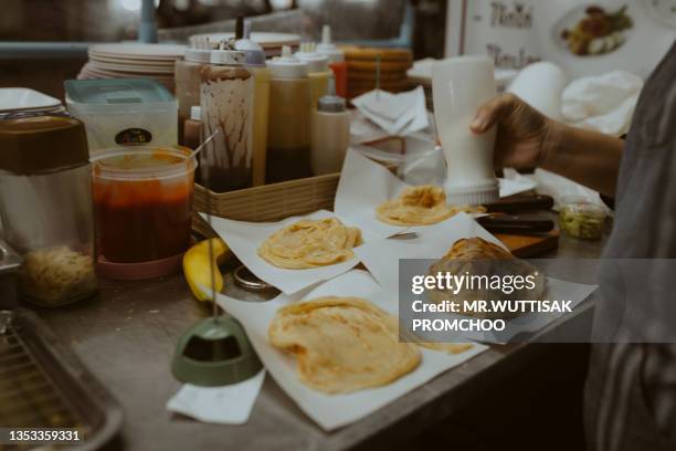 frying roti. - parantha stock pictures, royalty-free photos & images