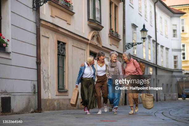 group of happy senior women walking and holding outdoors in town. - slovakia town stock pictures, royalty-free photos & images