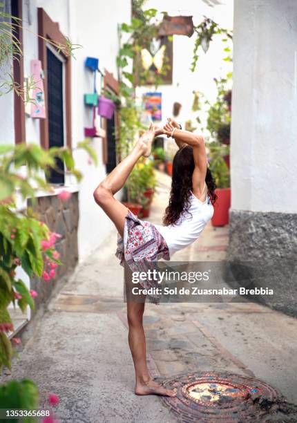 woman doing yoga in the streets of a small and picturesque andalusian town - andalucía de moda stock-fotos und bilder