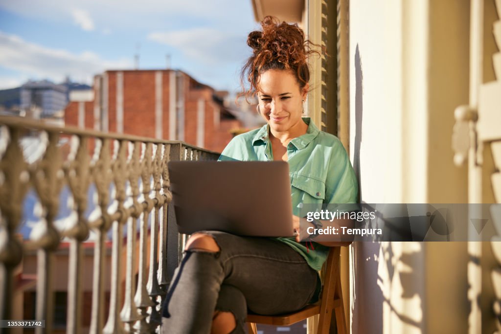 A young woman working from home with a laptop.