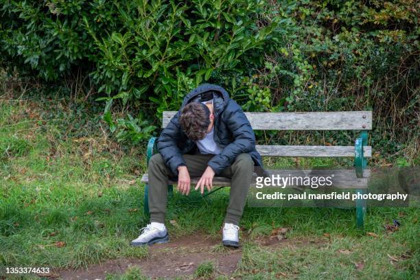 depressed teenager on bench - social exclusion stock pictures, royalty-free photos & images