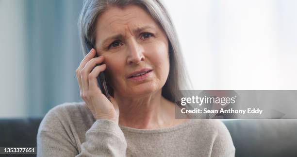 cropped shot of an attractive senior woman looking sad while busy on a phonecall at home - distraught elderly stock pictures, royalty-free photos & images