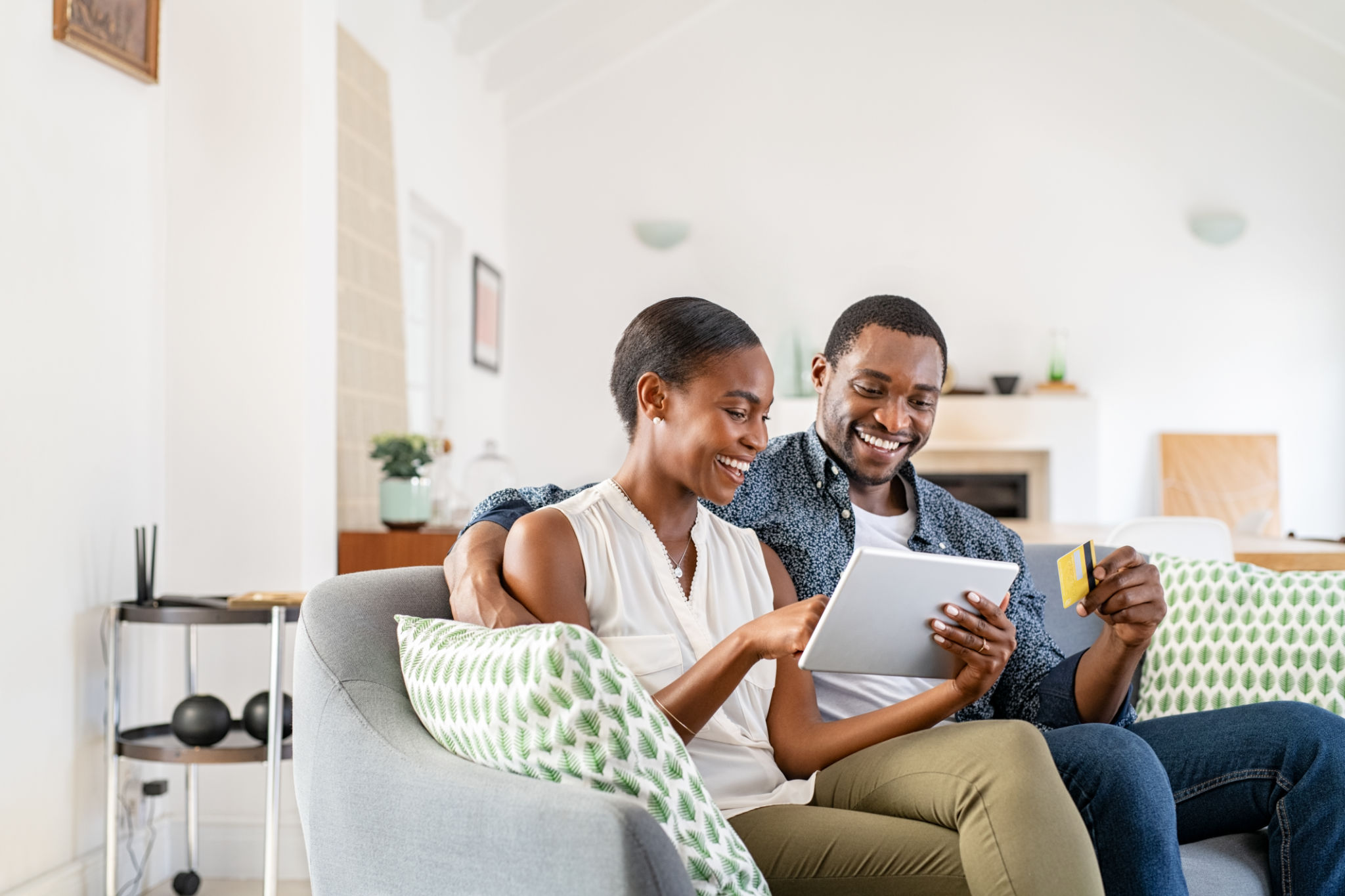Mature black couple doing online shopping with credit card card at home Mature black couple doing online shopping with credit card card at home