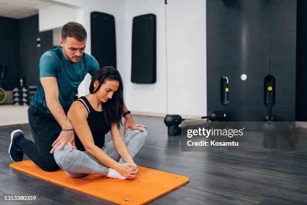 a fit woman doing a groin stretching exercise. she is in a sitting position, with bent knees and joined soles. - underliv bildbanksfoton och bilder