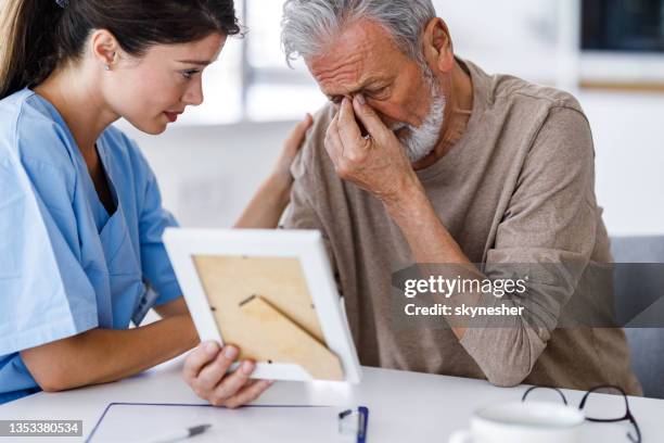 home caregiver consoling depressed senior man. - death stock pictures, royalty-free photos & images