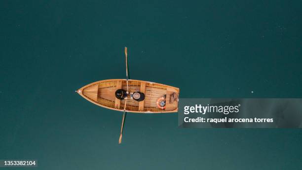 drone view of a couple rowing a boat on a lake - boat stock-fotos und bilder