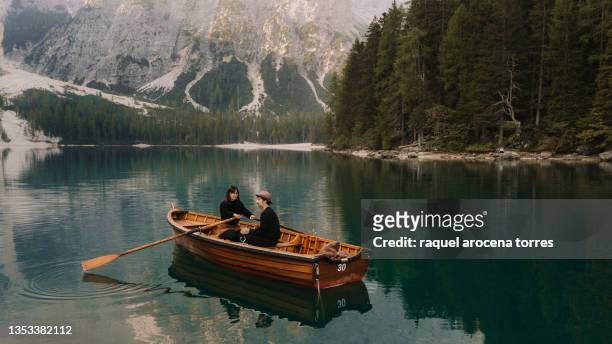 drone view of a couple rowing a boat on a lake - rowboat stockfoto's en -beelden