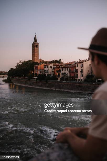 adult man observing verona from a bridge at sunset - verona italy stock pictures, royalty-free photos & images