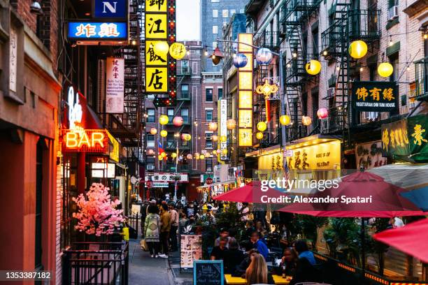 crowded illuminated street with restaurants in bars in chinatown, new york city, usa - chinese american stockfoto's en -beelden