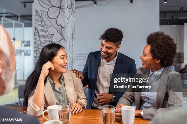 carefree and modern multiracial group of business people, enjoying their coffee break with casual conversation - meeting candid office suit stockfoto's en -beelden