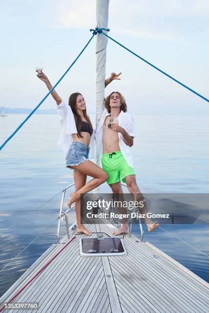 friends standing on the bow of a sailboat making funny faces while sailing - friend mischief stock pictures, royalty-free photos & images