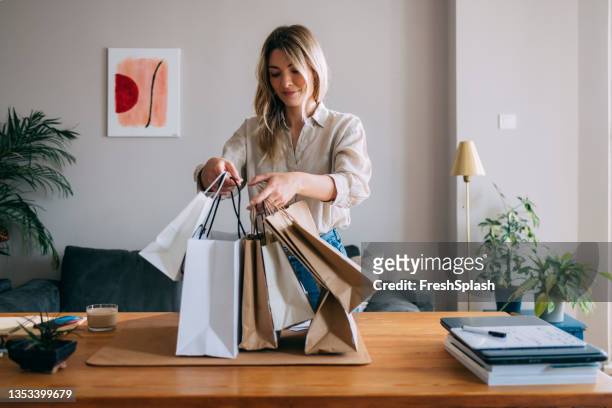 beautiful female holding paper bags at home - grocery bag stock pictures, royalty-free photos & images