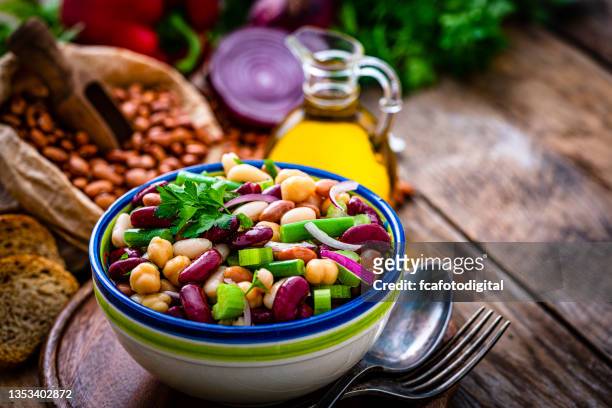 healthy fresh bean salad bowl on rustic table. - chick pea salad stock pictures, royalty-free photos & images