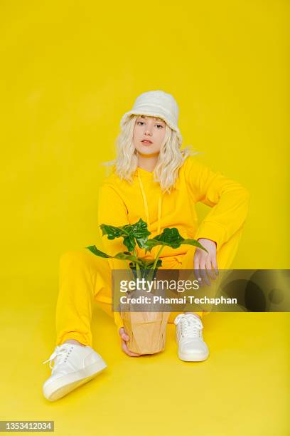 young woman holding pot of plant - art modeling studio stock-fotos und bilder