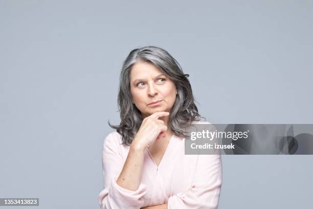 headshot of thoughtful mature woman - woman thinking hand on chin stock pictures, royalty-free photos & images