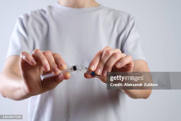 a broken syringe for injection of the covid 19 vaccine in the hands of a woman, a medical worker. movement against vaccination, refusal of it. the girl refused to be vaccinated. anti-immunization campaign. the concept of freedom of choice and human rights - anti vaccine stock-fotos und bilder