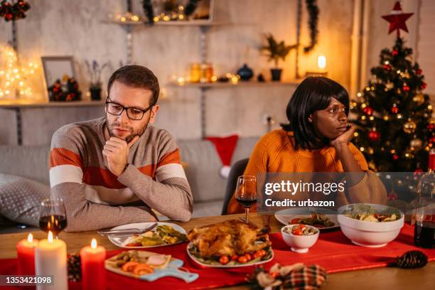 unhappy couple ignoring each other at christmas dinner - christmas stress stock pictures, royalty-free photos & images