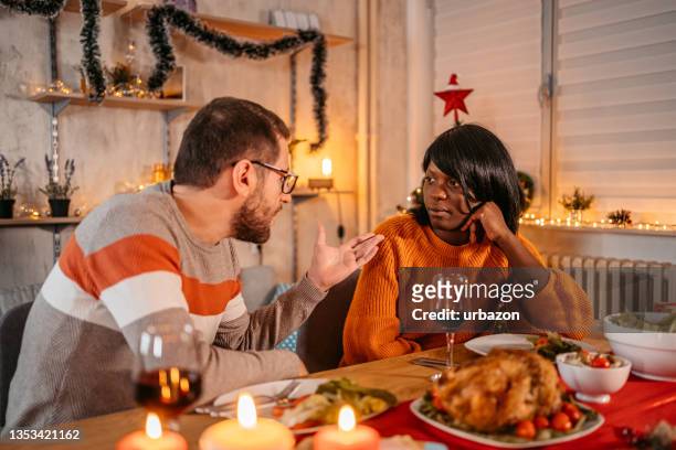 unhappy couple arguing during christmas dinner - christmas angry stock pictures, royalty-free photos & images