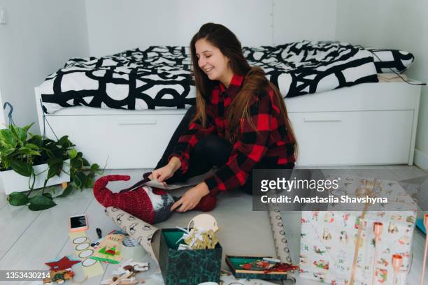 young woman wrapping christmas gifts at home - luxury lounges stock pictures, royalty-free photos & images