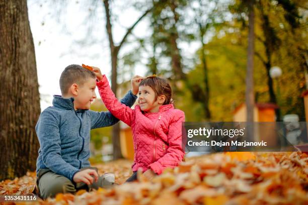 kids playing in public park in autumn - setembro imagens e fotografias de stock