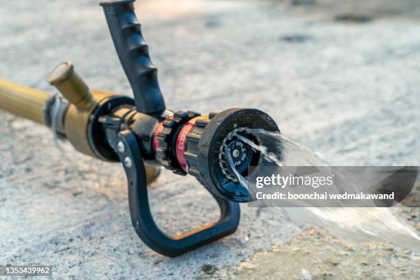 water jet splashing from a fire fighting firehose nozzle. - brandslang bildbanksfoton och bilder