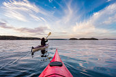 Adventurous Woman on Sea Kayak paddling in the Pacific Ocean.