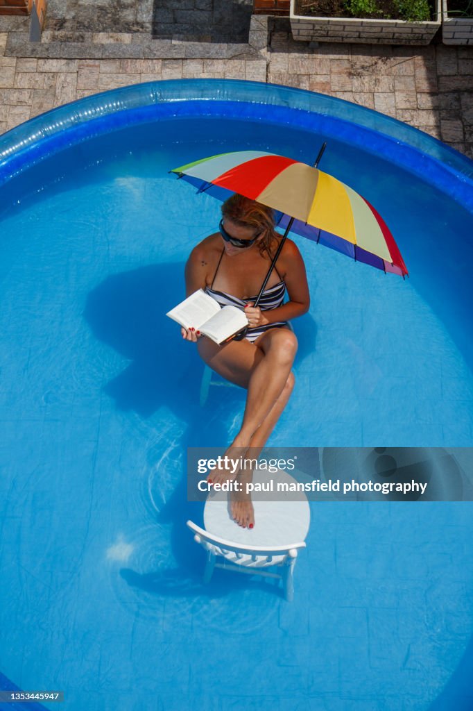 Lady reading book in pool