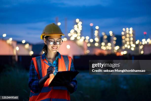 female engineer inspects in an industrial refinery. - oil and gas workers stock-fotos und bilder