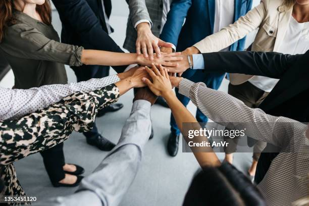 colleagues putting hands together at work - handen ineengevouwen stockfoto's en -beelden