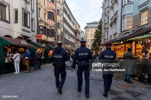 Police officers monitor compliance with the lockdown in Innsbruck's old town during the first day of a nationwide lockdown for people not yet...