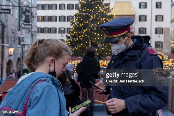 Police officers monitor compliance with the lockdown in Innsbruck's old town during the first day of a nationwide lockdown for people not yet...