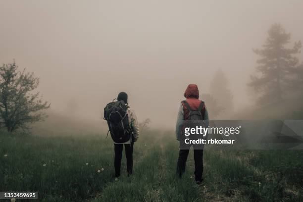 two lost hikers with backpacks standing on a trail in a wooded area in foggy weather - hot weather bildbanksfoton och bilder