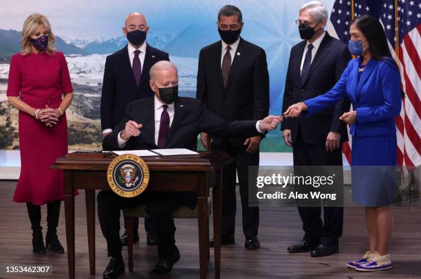 President Joe Biden hands a signing pen to Interior Secretary Deb Haaland as he signs an executive order to help improve public safety and justice...