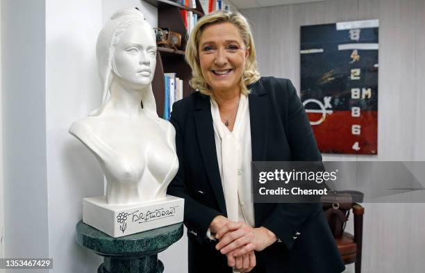 French far-right party Rassemblement National leader and candidate for the 2022 French presidential election Marine Le Pen poses next to a bust of...