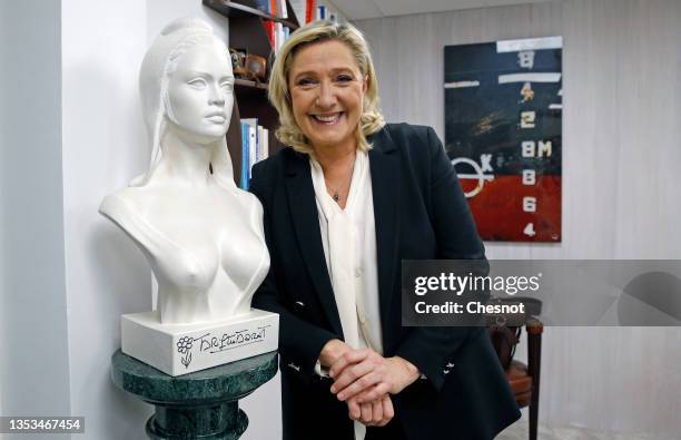 French far-right party Rassemblement National leader and candidate for the 2022 French presidential election Marine Le Pen poses next to a bust of...